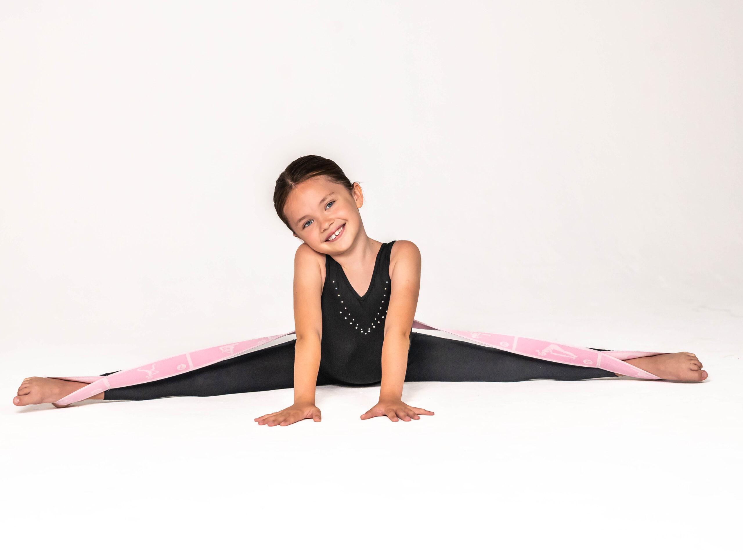 Jauna gimnastė šypsosi atlikdama špagatą